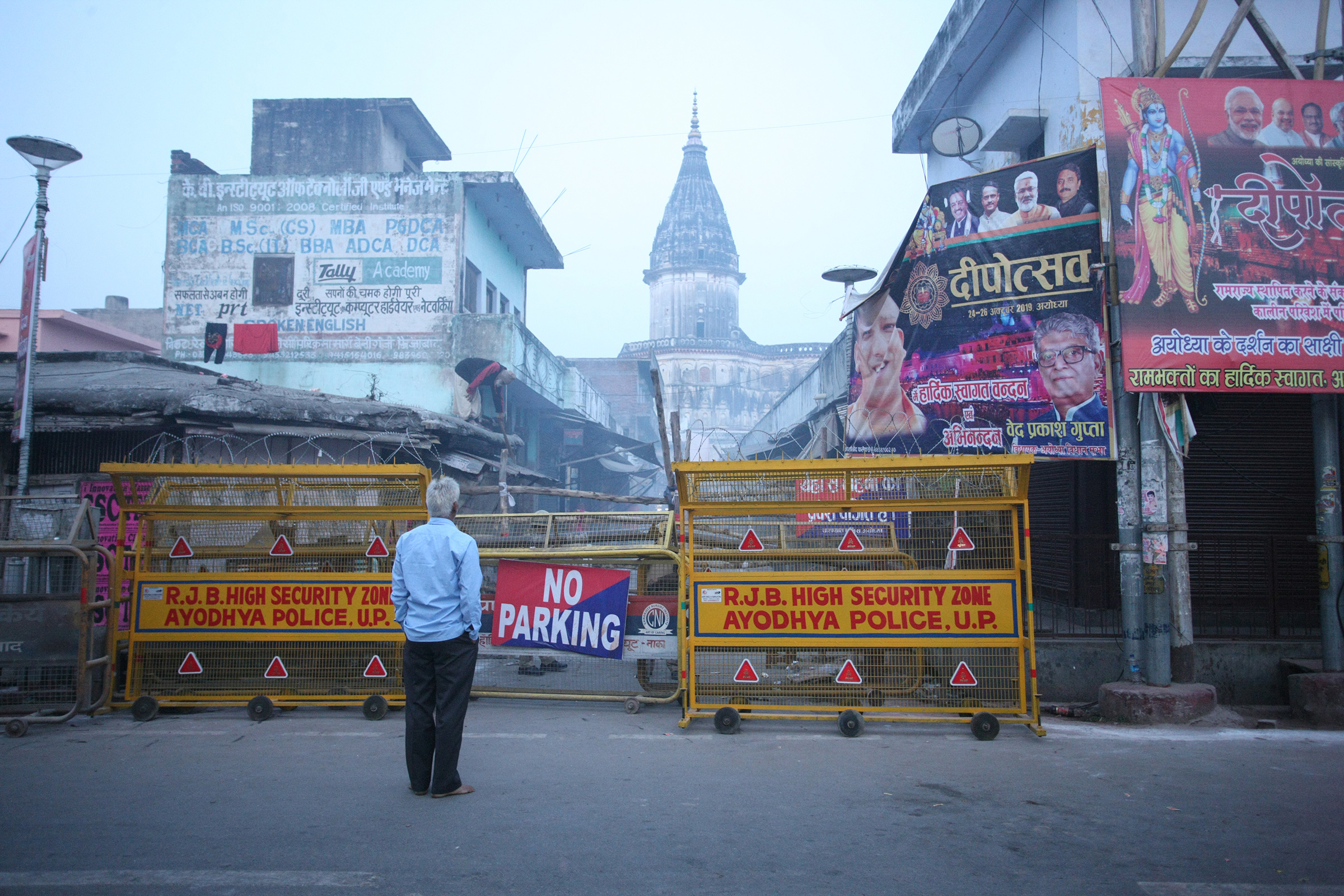 A local man looks on through barricade on street near Hanmuna Gadhi temple in Ayodhya on Nov. 9, 2019, ahead of a Supreme Court verdict on the future of a disputed religious site in the holy city.
