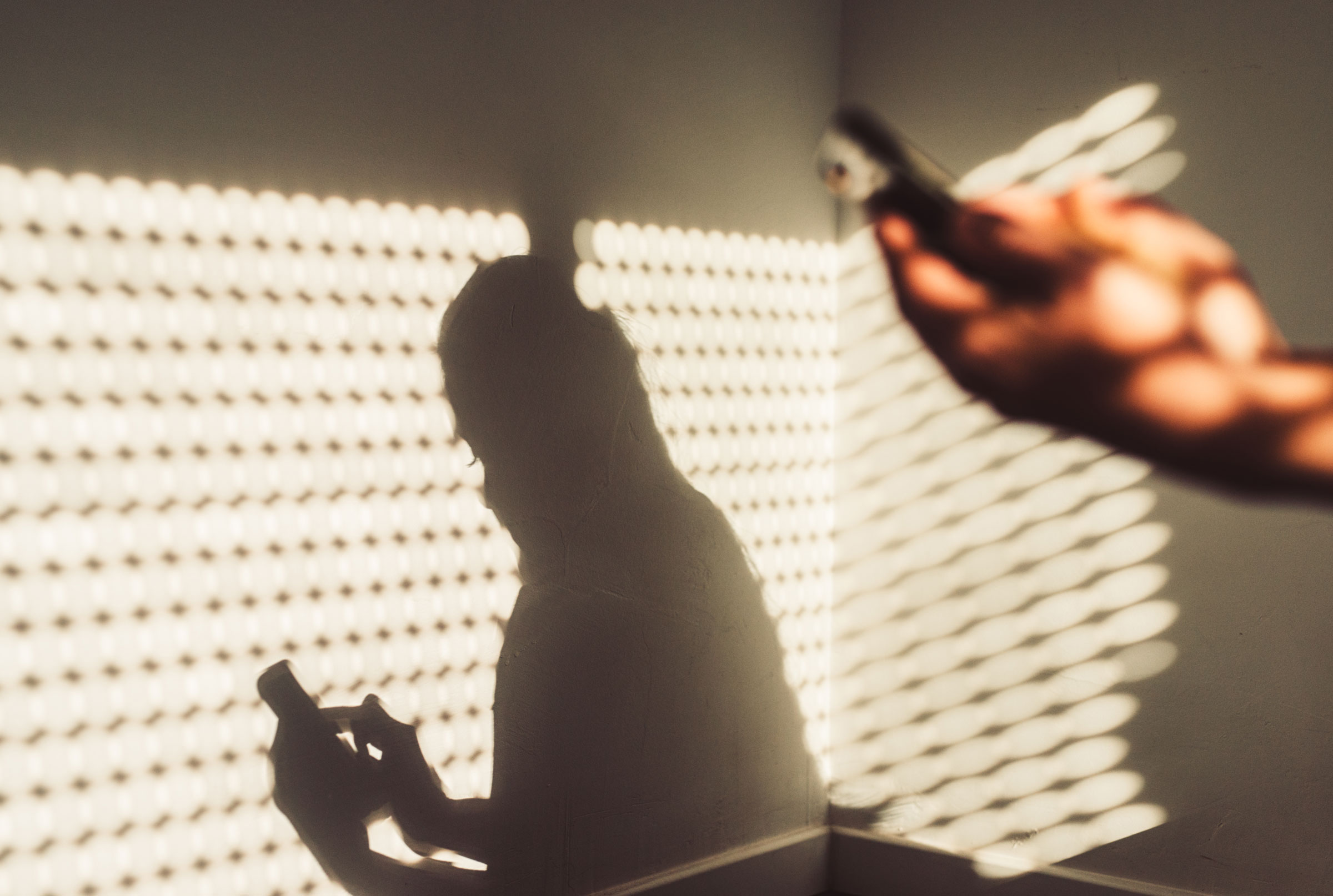 Shadow of a woman using a smartphone