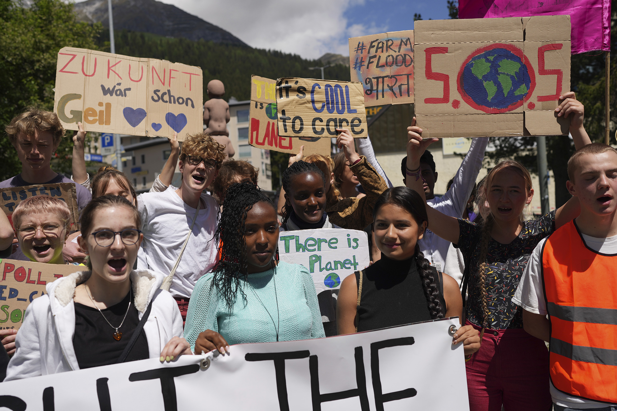 Elizabeth Wathuti protests alongside climate activists Vanessa Nakate and Helena Gualinga at the World Economic Forum in Davos, Switzerland, May 26, 2022. (Evgeniy Maloletka—AP)