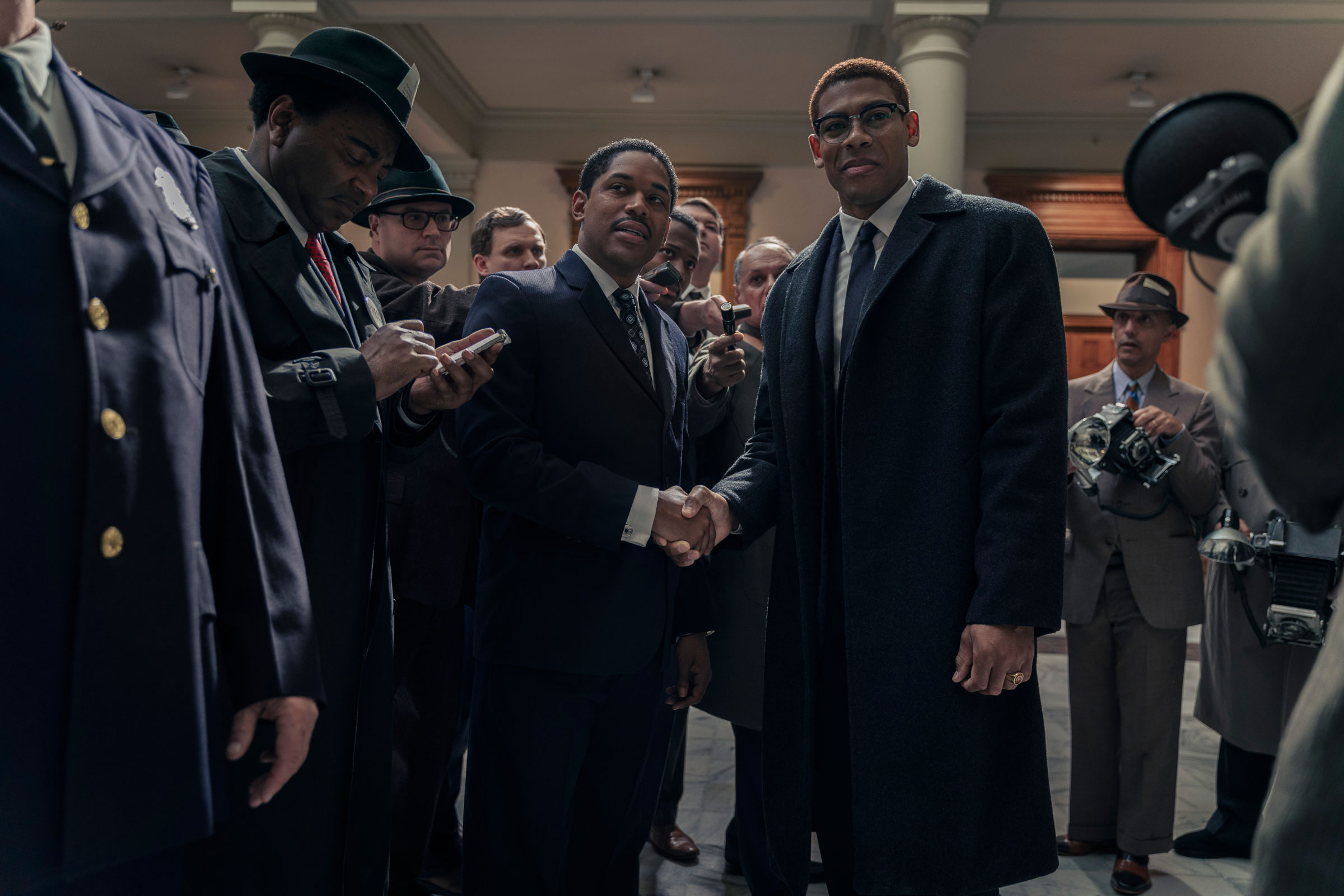 Martin Luther King Jr., played by Kelvin Harrison Jr., and Malcolm X, played by Aaron Pierre, are surrounded by reporters in the US Senate as seen in Genius: MLK/X.
