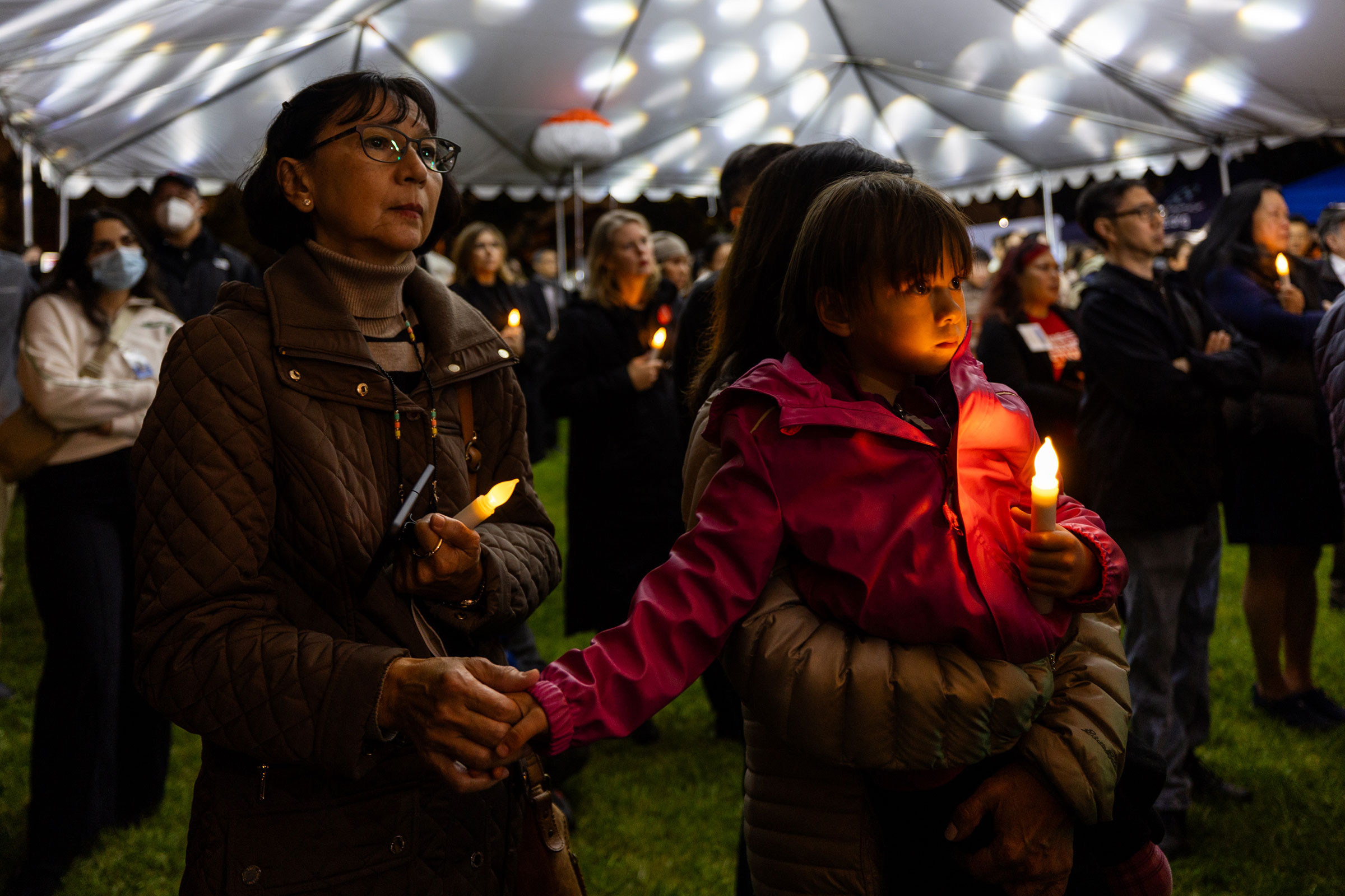 Mourners hold candles during a candlelight vigil to commemorate the first anniversary of a mass shooting in Monterey Park in Los Angeles on Jan. 21, 2024.