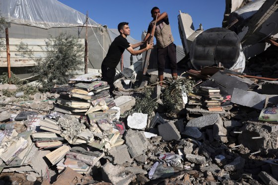 Palestinians collect books from the rubble of a cultural centre following an Israeli strike in Rafah in the southern Gaza Strip on Nov.18, amid ongoing battles between Israel and the Palestinian group Hamas.