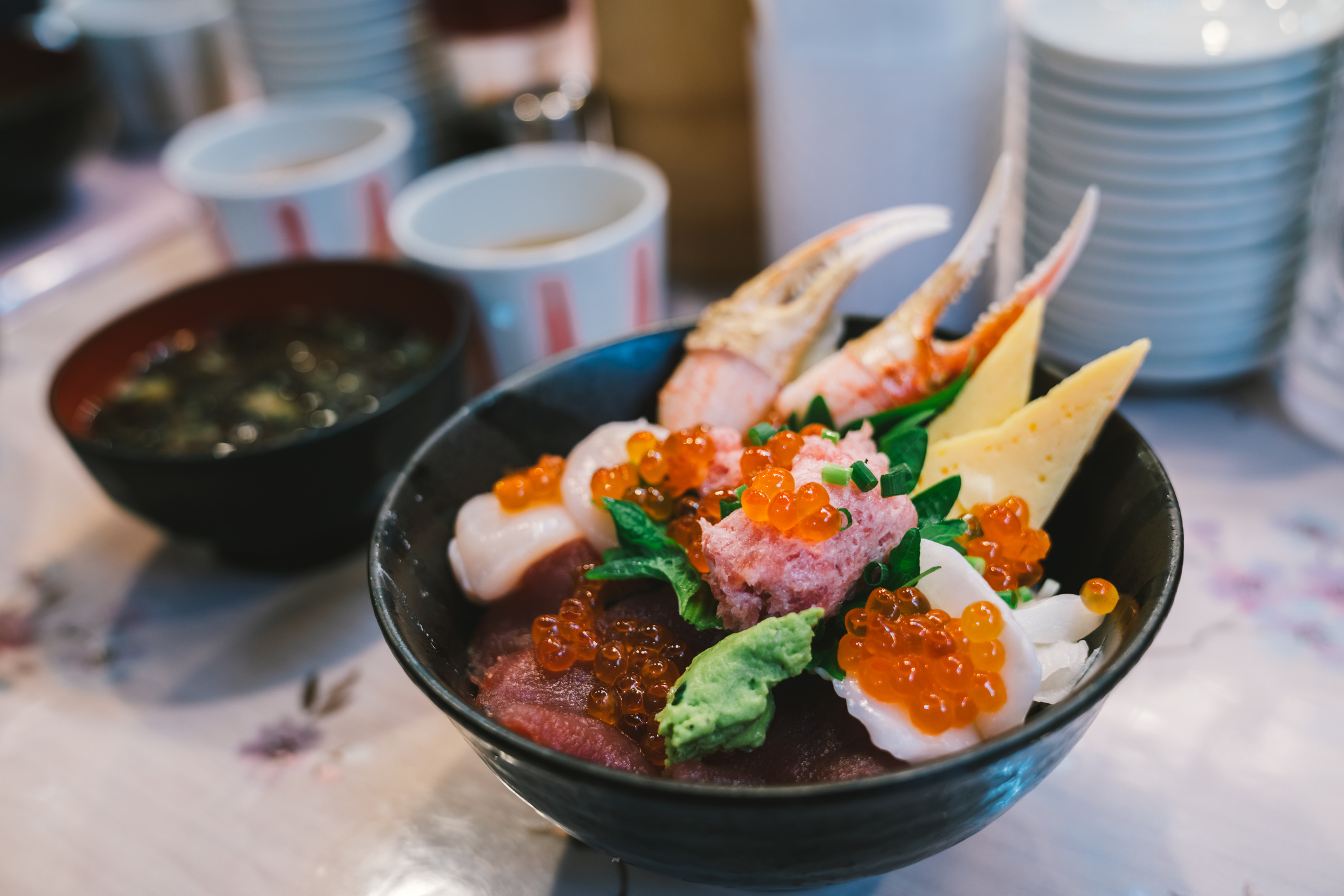 Chirashi Sushi Don or sashimi donburi, Japanese seafood rice bowl topped with mixed raw tuna fish, salmon roe, hotate scallop, engawa, crab claw meat, and wasabi. Japan famous traditional food concept