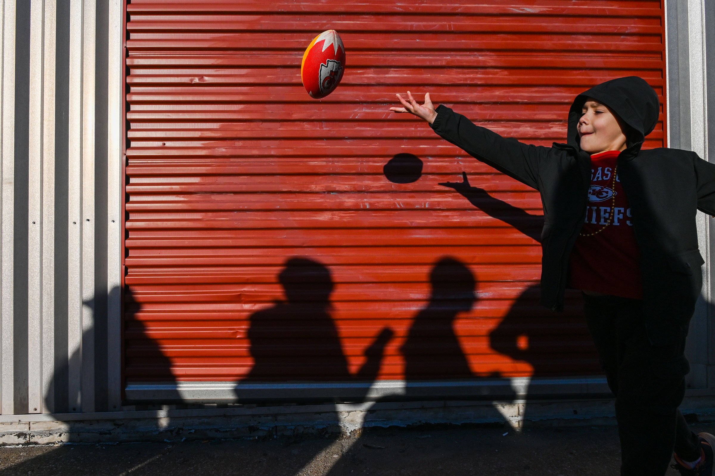 A fan plays football before the parade.