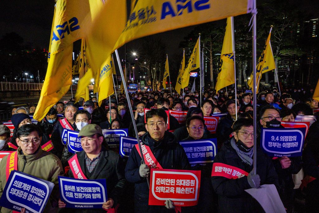 Doctors hold placards that read "Opposition to the increase in medical schools" as they gather to protest against the government's plan to raise the annual enrolment quota at medical schools by 2000 in Seoul on Feb. 15, 2024.