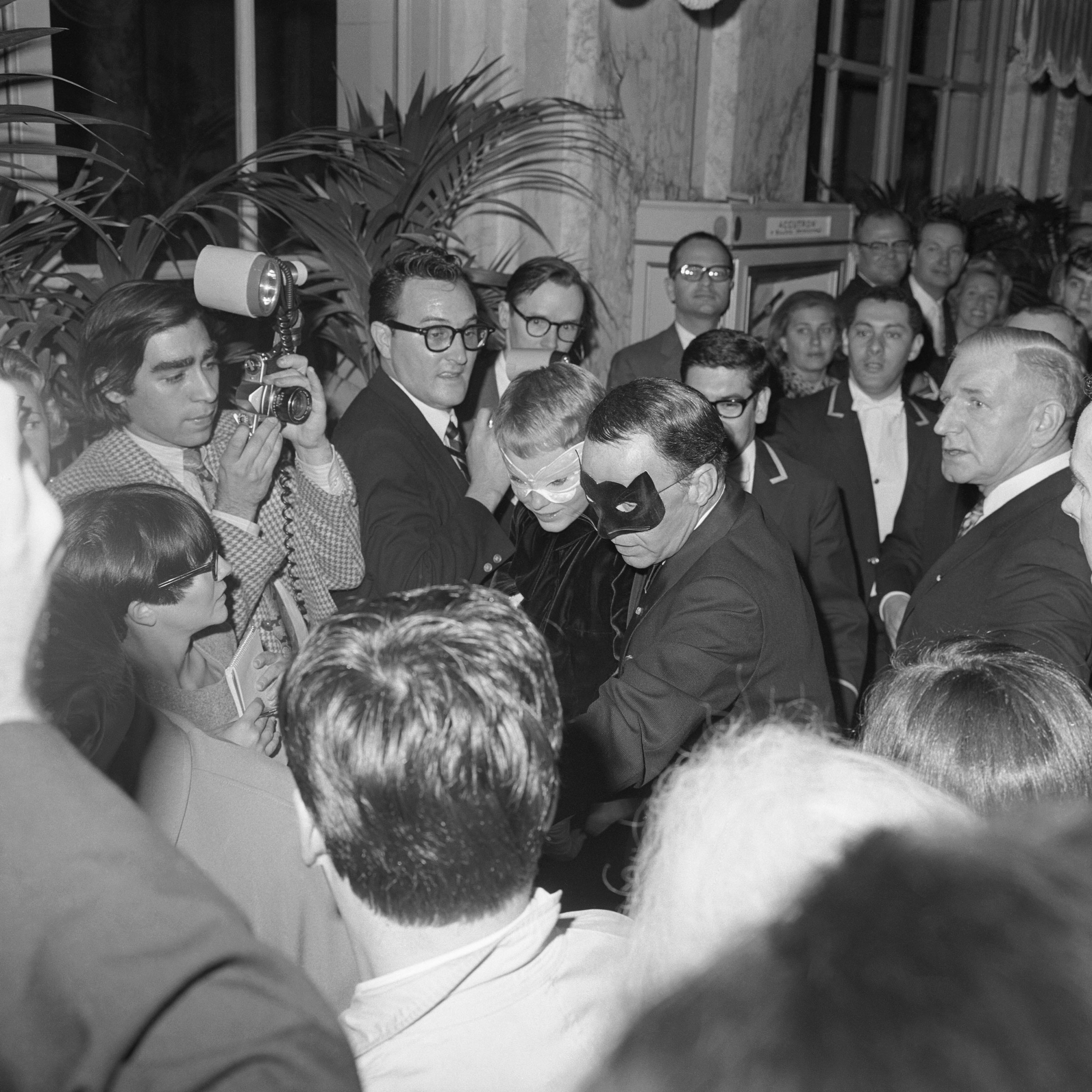 Reporters swarm Frank Sinatra and Mia Farrow as they arrive at Truman Capote’s Black and White Ball.