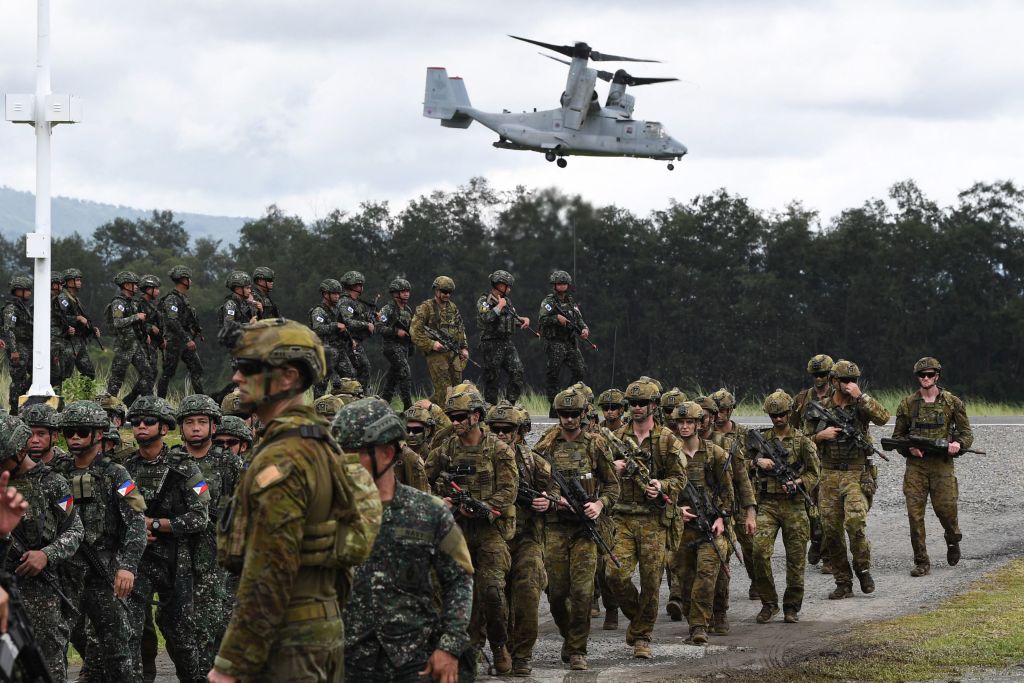 Philippine and Australian soldiers march in formation while a US marines V-22 Osprey hovers above during military exercise Alon, a joint amphibious landing drill held at a naval base in San Antonio town in Zambales province, north of Manila on Aug. 25, 2023.