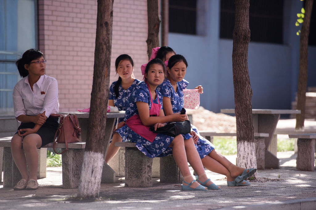 Workers rest outside the Kim Jong Suk textile factory during a guided tour for visiting foreign media, in Pyongyang on Sept. 7, 2018.