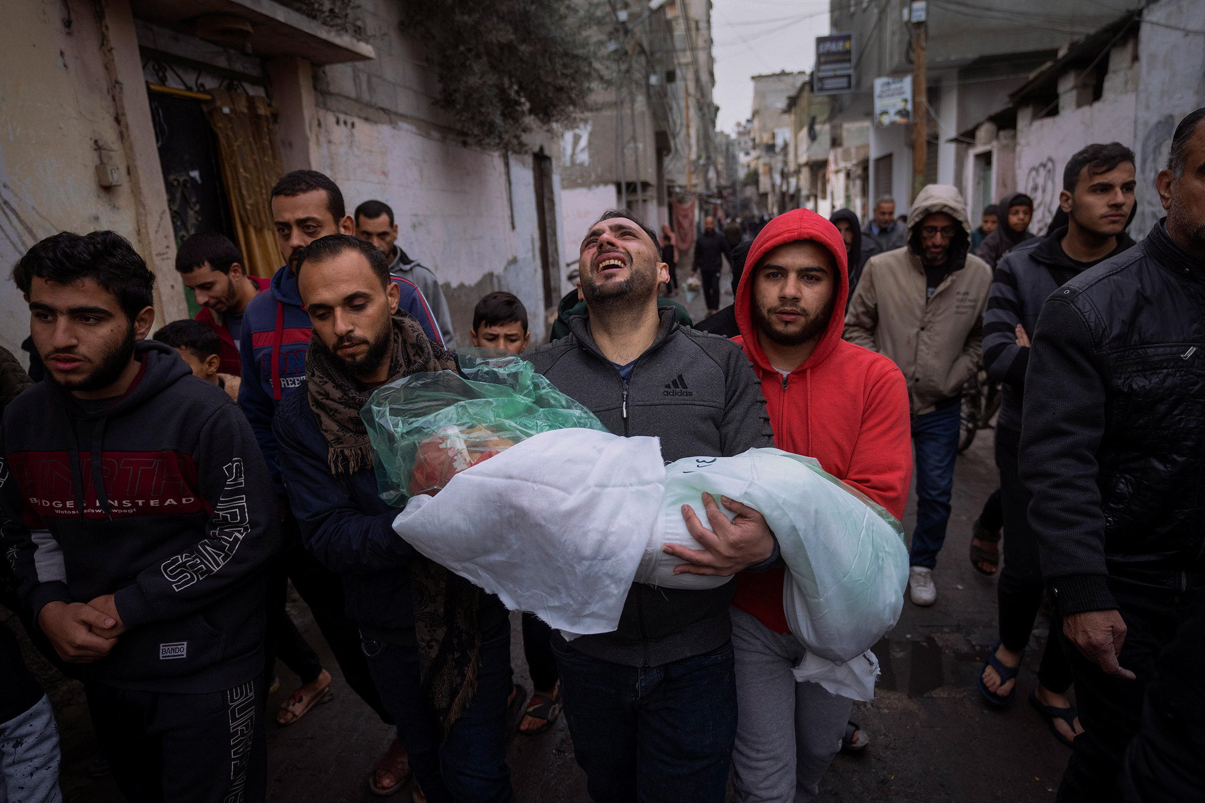 Mohammad Shouman carries the body of his daughter, Masa, who was killed in an Israeli bombardment of the Gaza Strip, during her funeral in Rafah, southern Gaza, on Jan. 17.