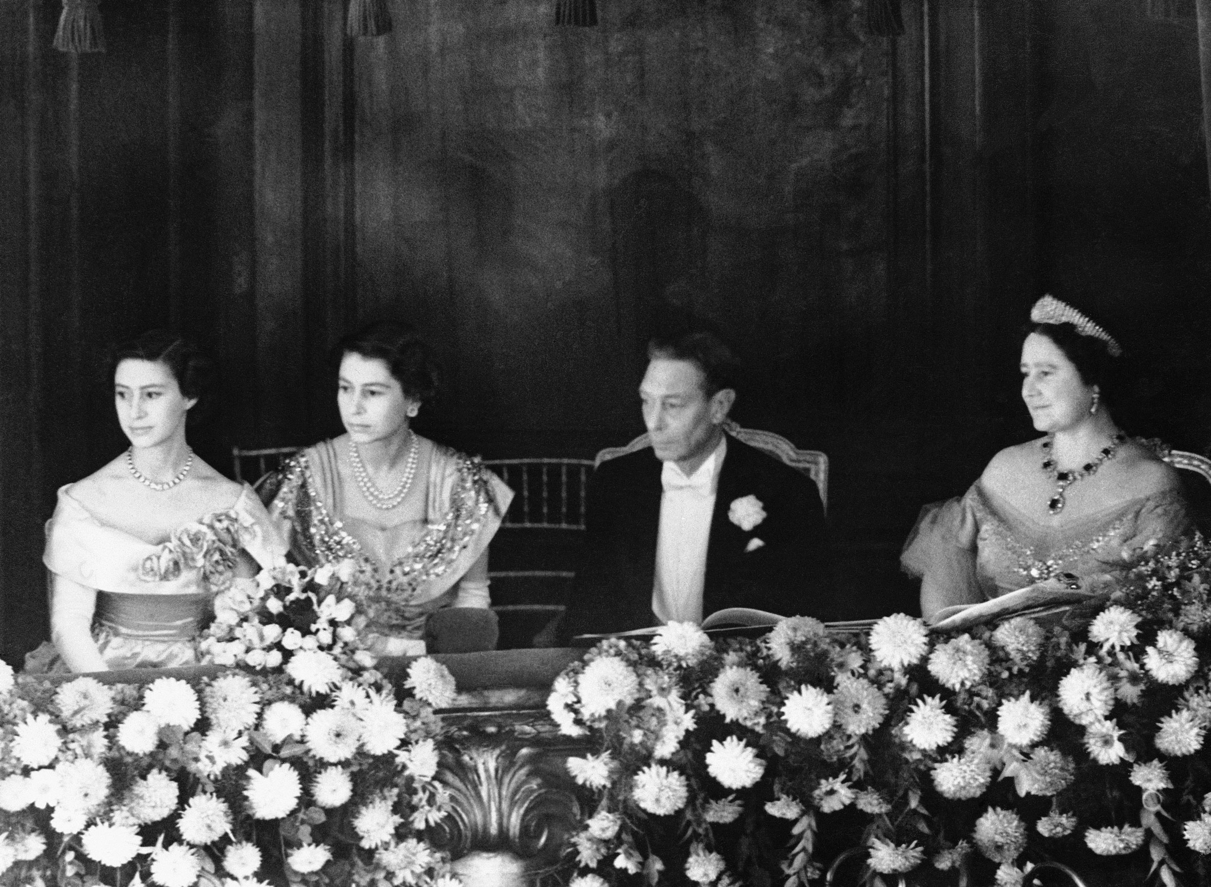 King George VI and Queen Elizabeth sit with Princesses Margaret Rose and Elizabeth in their box in London’s Palladium Theater, on Nov. 13, 1950.