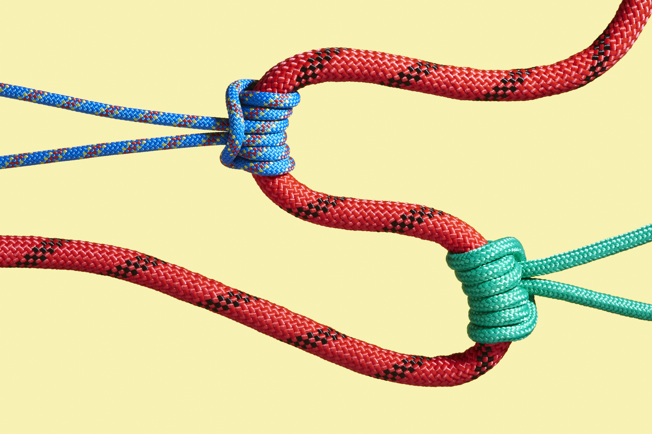 Two ropes pulling on a larger rope to shape its path