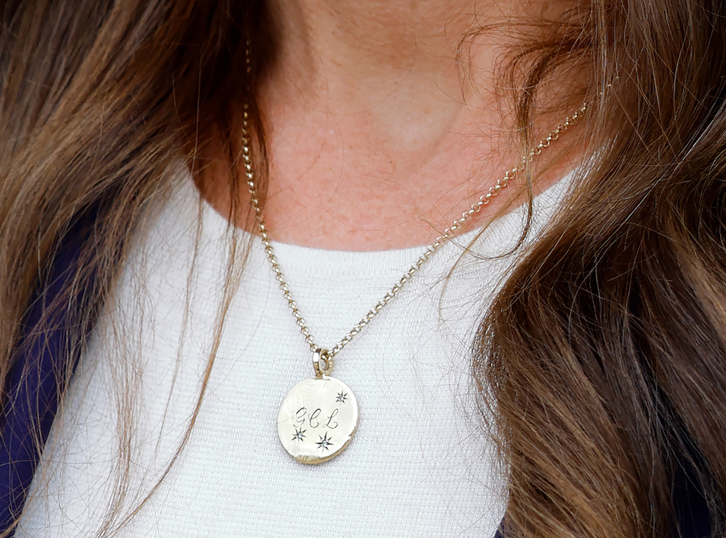 Catherine, Princess of Wales, wears a necklace bearing the initials G, C and L of her children Prince George of Wales, Princess Charlotte of Wales and Prince Louis of Wales.