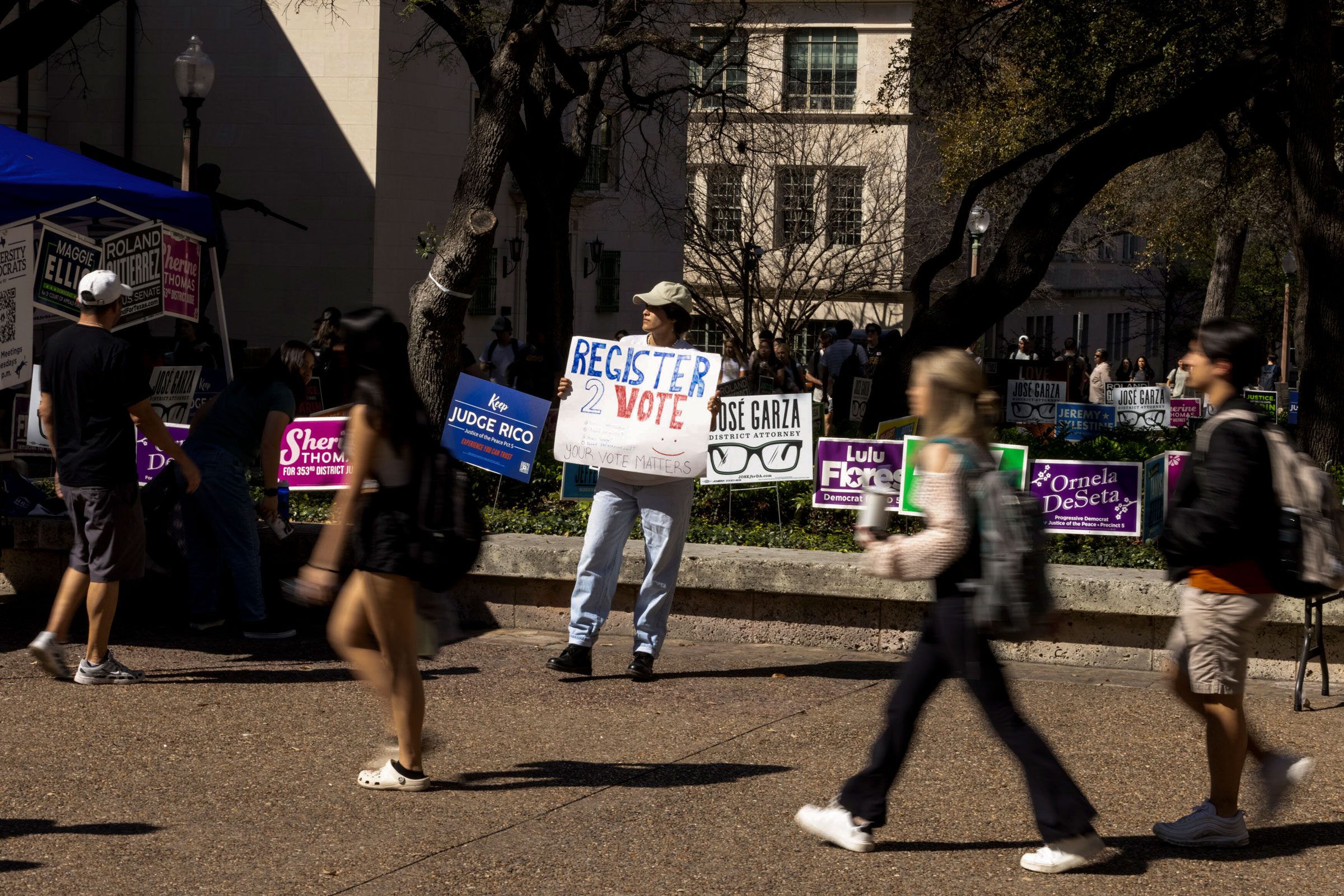 An organizer encourages people to vote outside a polling place at the University of Texas at Austin, on March 5, 2024.