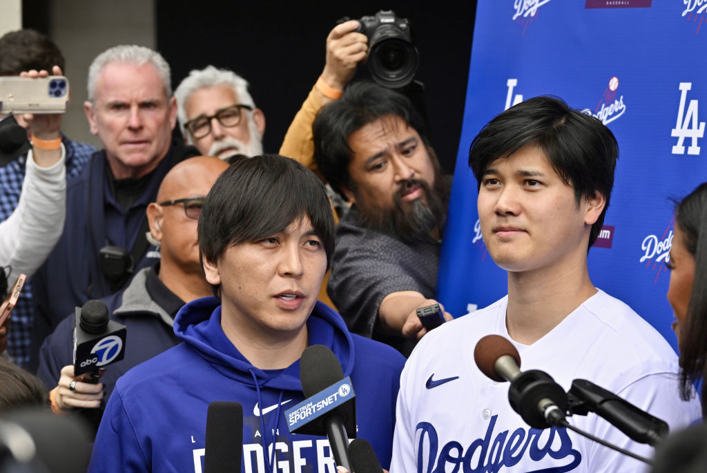 Shohei Ohtani, right, of the Los Angeles Dodgers speaks to the media with the help of his interpreter Ippei Mizuhara during DodgerFest a celebration of the upcoming season with live entertainment, behind-the-scenes experiences, food, drinks and meeting the newest Dodgers at Dodger Stadium in Los Angeles on Feb. 3, 2024. 