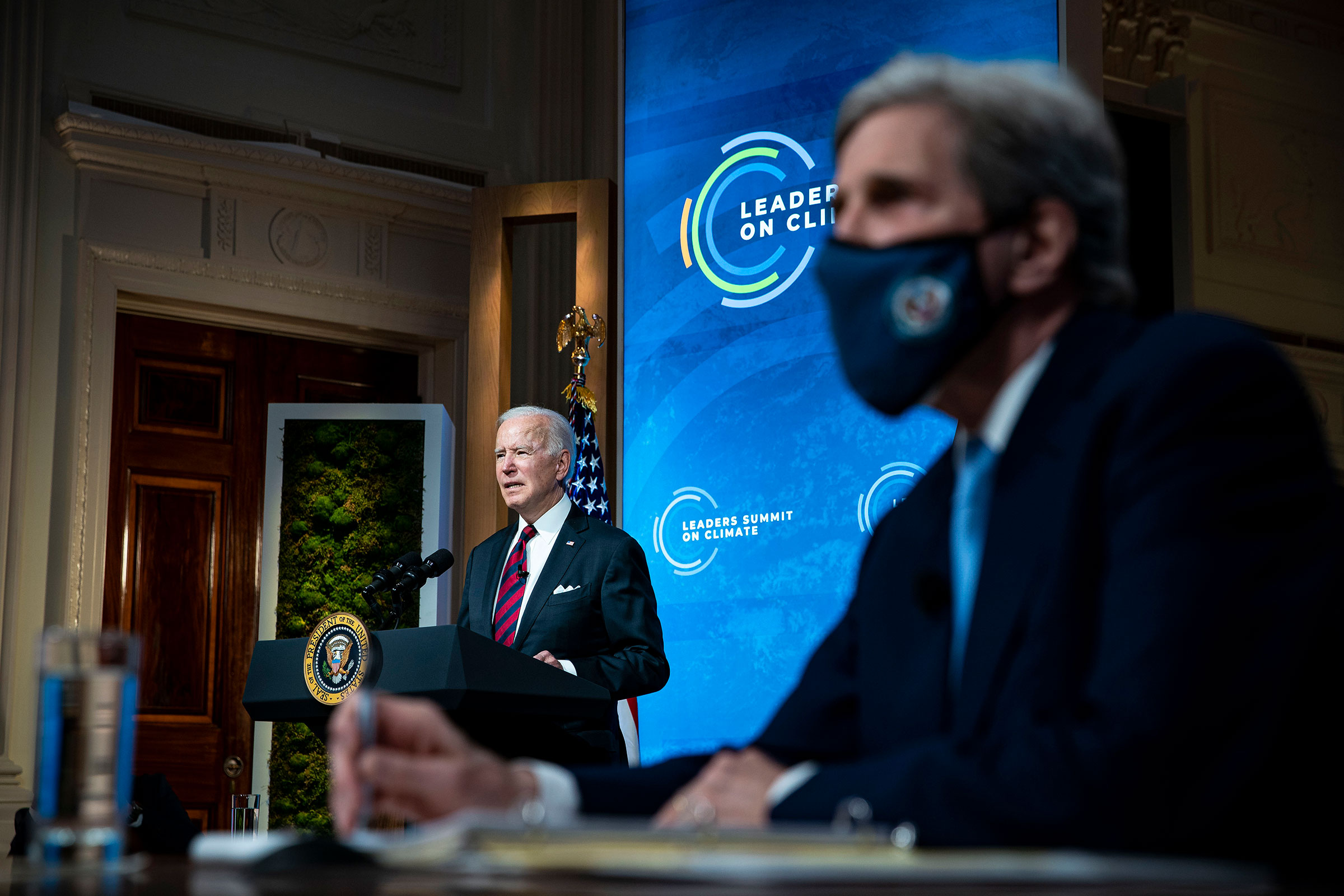 President Joe Biden delivers remarks as John Kerry listens during a virtual Leaders Summit on Climate with 40 world leaders at the White House on April 22, 2021.