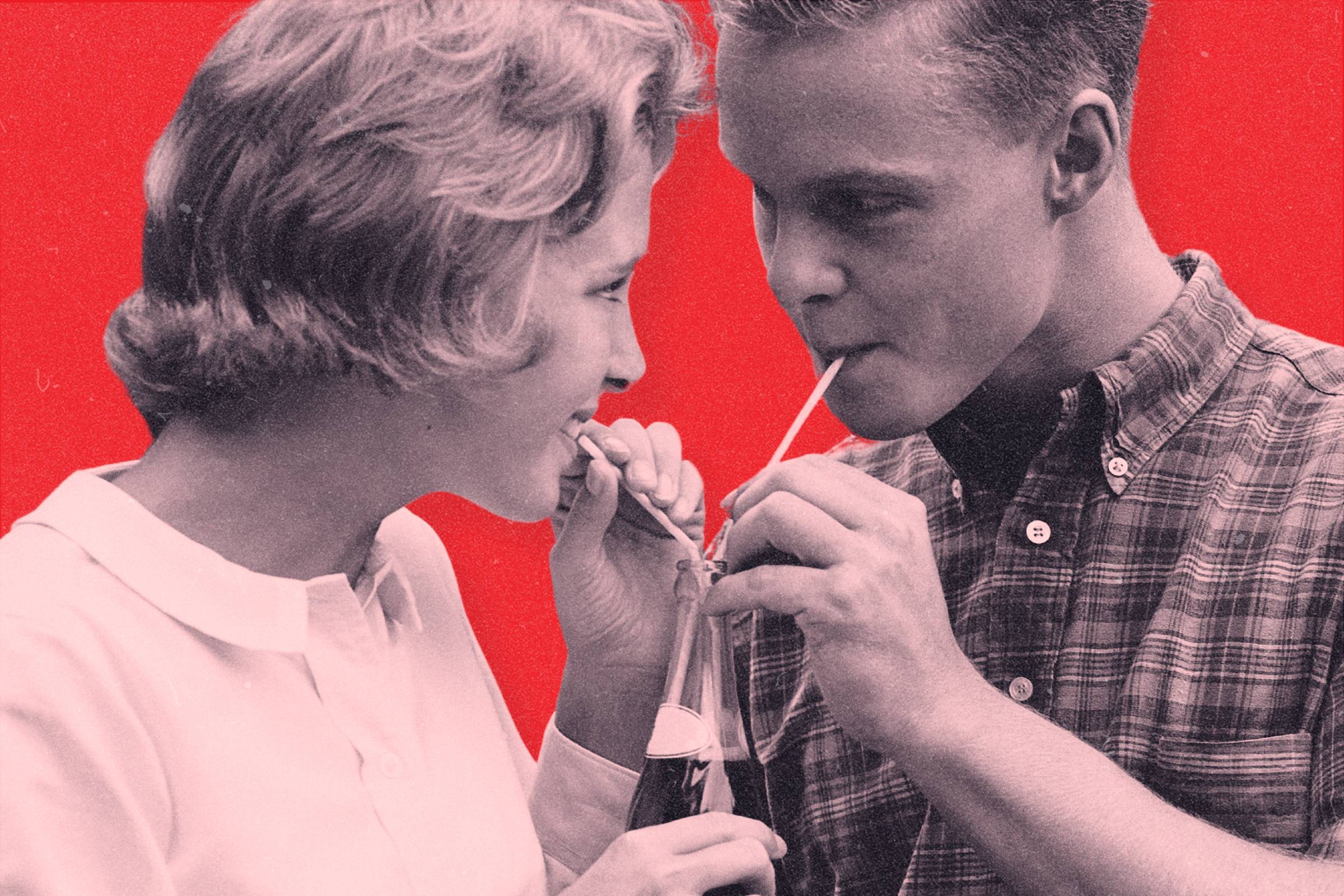 A vintage photograph of a couple drinking out of a soda bottle with two straws
