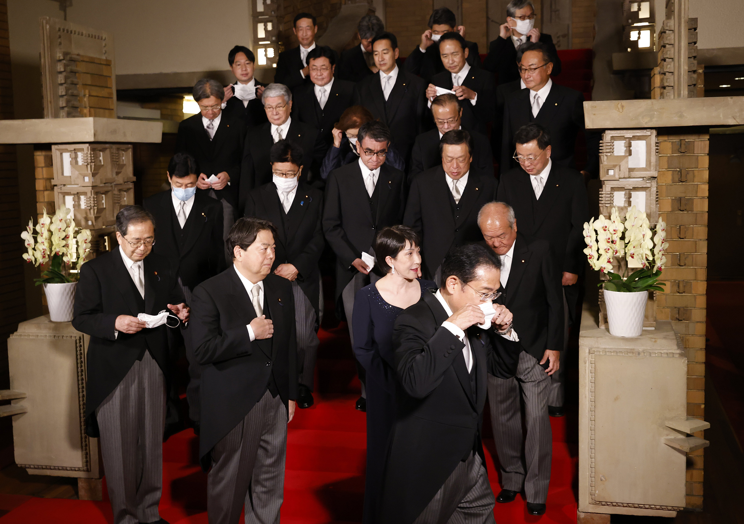 Ministers bow to Japan's Prime Minister Fumio Kishida as they leave from a photo session at Kishida's residence in Tokyo, Aug. 10, 2022. Kishida reshuffled his cabinet on this day to rid his administration of any links to Unification Church, following a low approval rating.