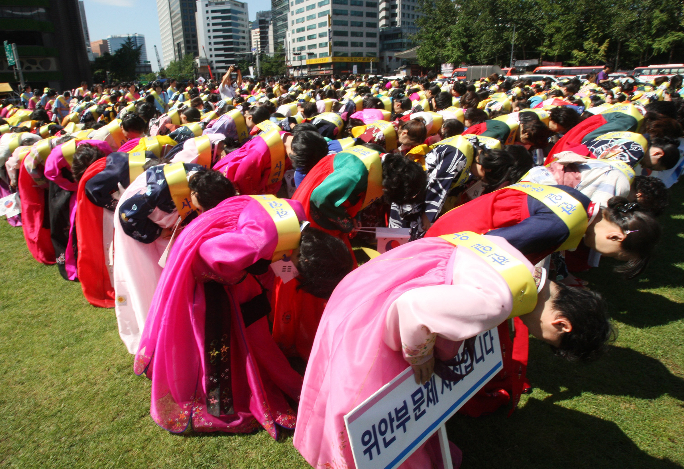 Japanese members of Unification Church bow as an act of apology for the war time Korean sex slaves conducted by Japanese military during a rally ahead of an anniversary celebration of Korea’s liberation from Japan’s colonial rule, in Seoul, Aug. 14, 2012.
