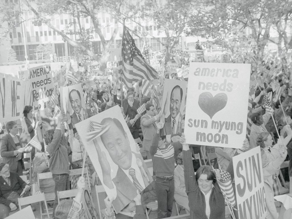 With American flags liberally scattered among huge posters of Rev. Sun Myung Moon, a crowd of his followers demonstrates in the park outside the United States District Courthouse on Oct. 22, 1981.