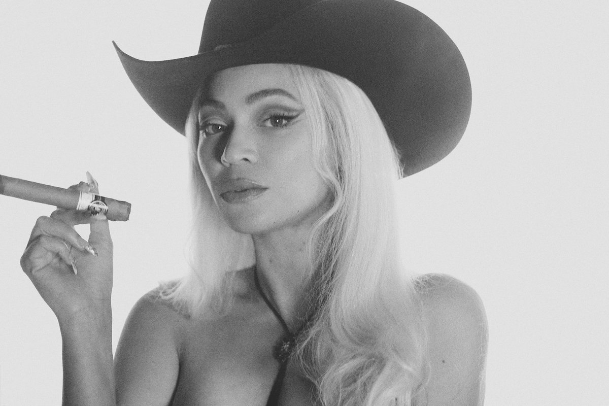 Beyoncé in a cowboy hat smoking a cigar