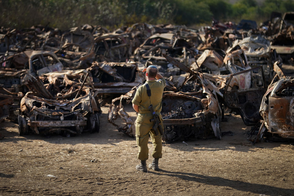 An Israeli soldier views a storage site containing hundreds of destroyed vehicles after the Oct. 7 Hamas attacks in Tkuma, Israel, on Nov. 8, 2023.