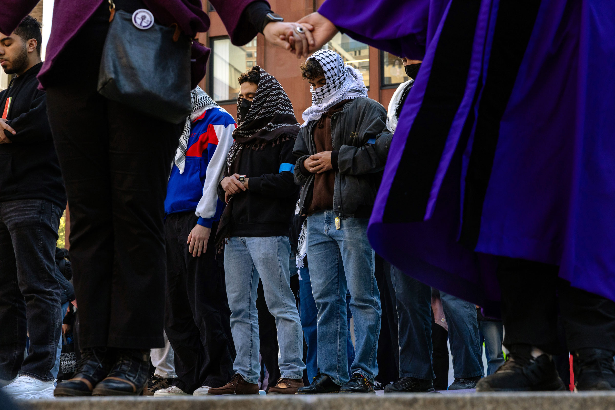 People pray as New York University students set up a tent encampment in Gould Plaza at NYU Stern School of Business on April 22, 2024.
