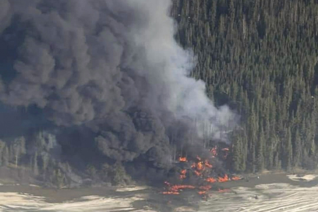 A fire burns after a Douglas C-54 Skymaster plane crashed into the Tanana River outside Fairbanks, Alaska, Tuesday, April 23, 2024.