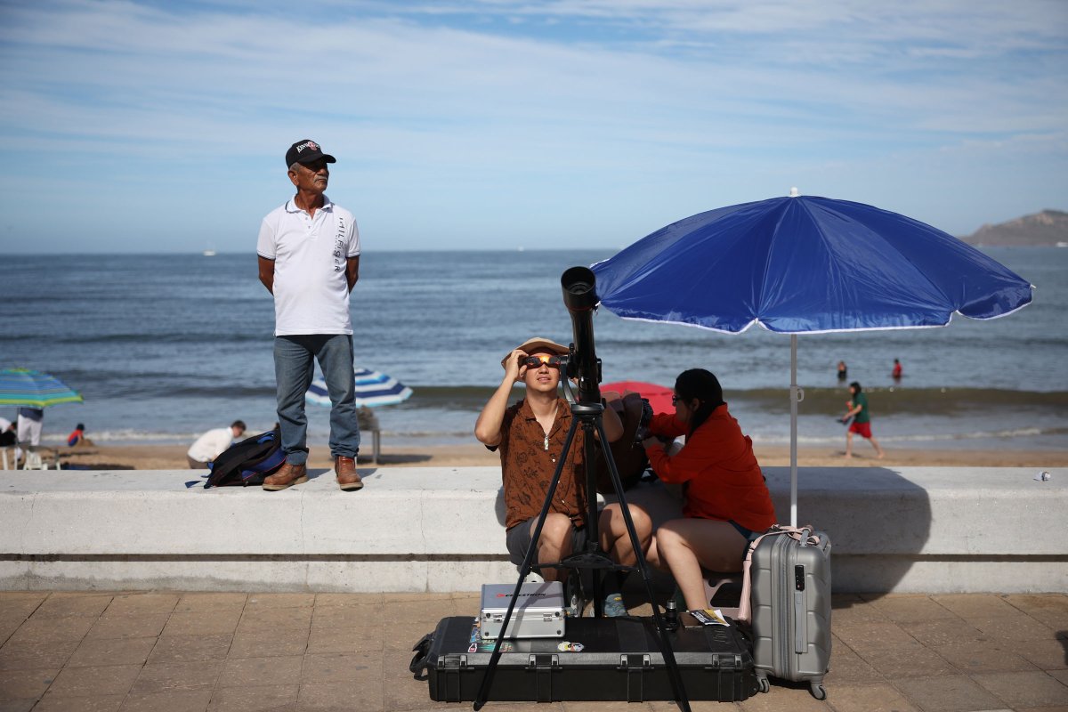 People prepare their telescope to see the eclipse in Mazatlan, Mexico.