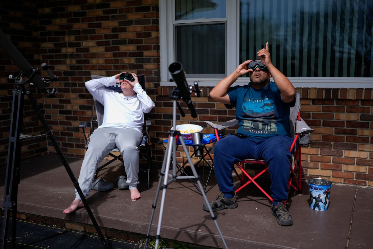 Melissa, left, and Michael Richards watch through solar goggles as the moon partially covers the sun during a total solar eclipse, as seen from Wooster, Ohio.