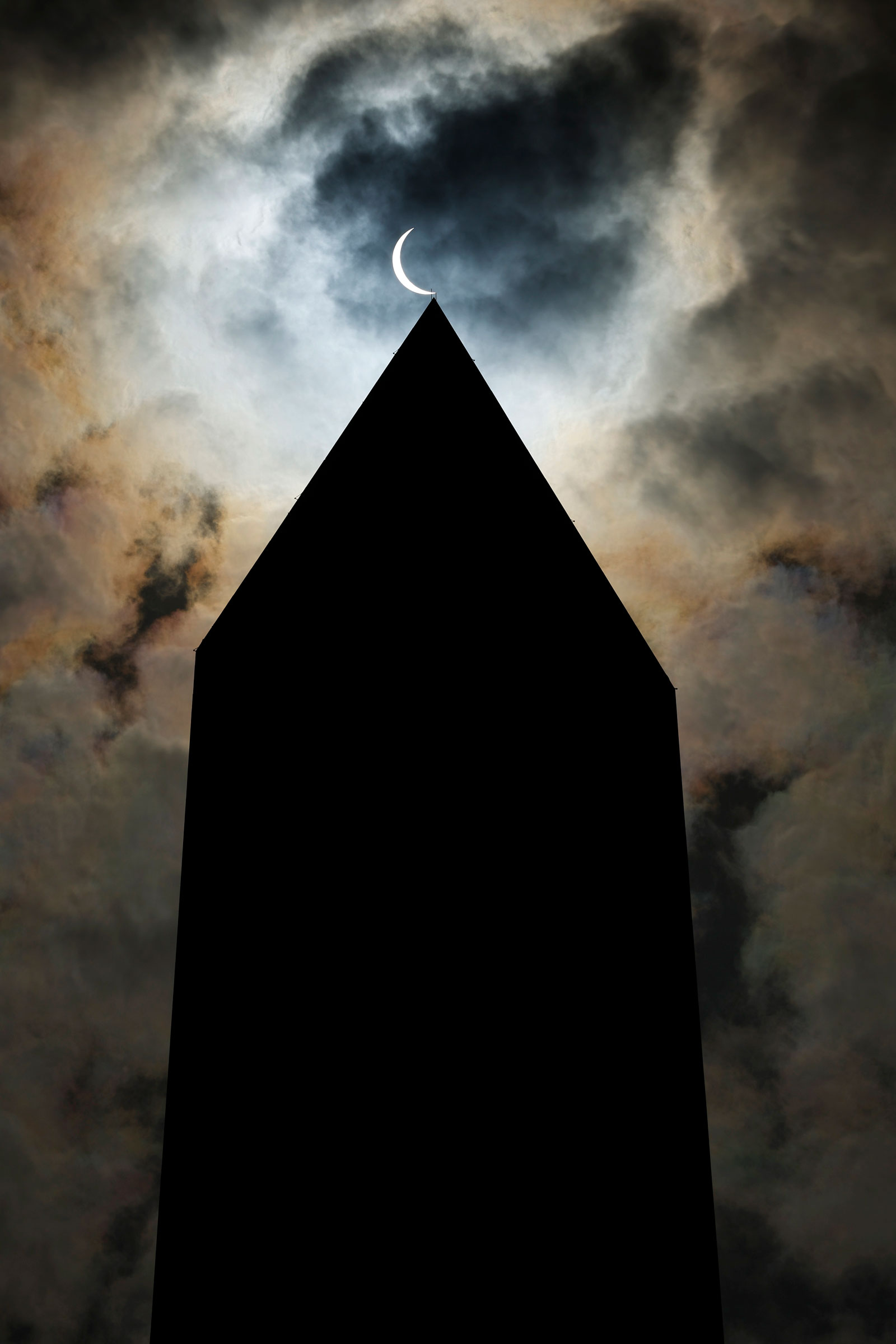 The solar eclipse is seen above the Washington Monument in Washington, D.C.