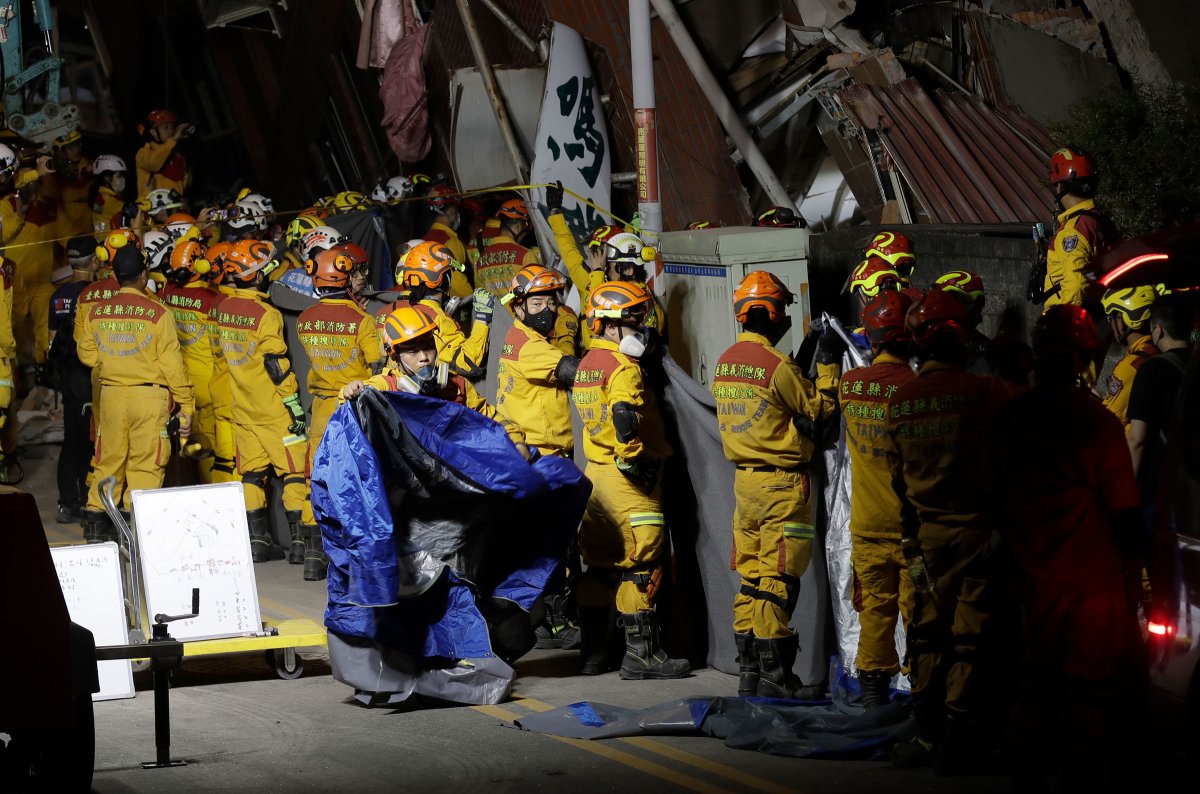 Firefighters prepare to move victims' bodies outside a collapsed building during a rescue operation