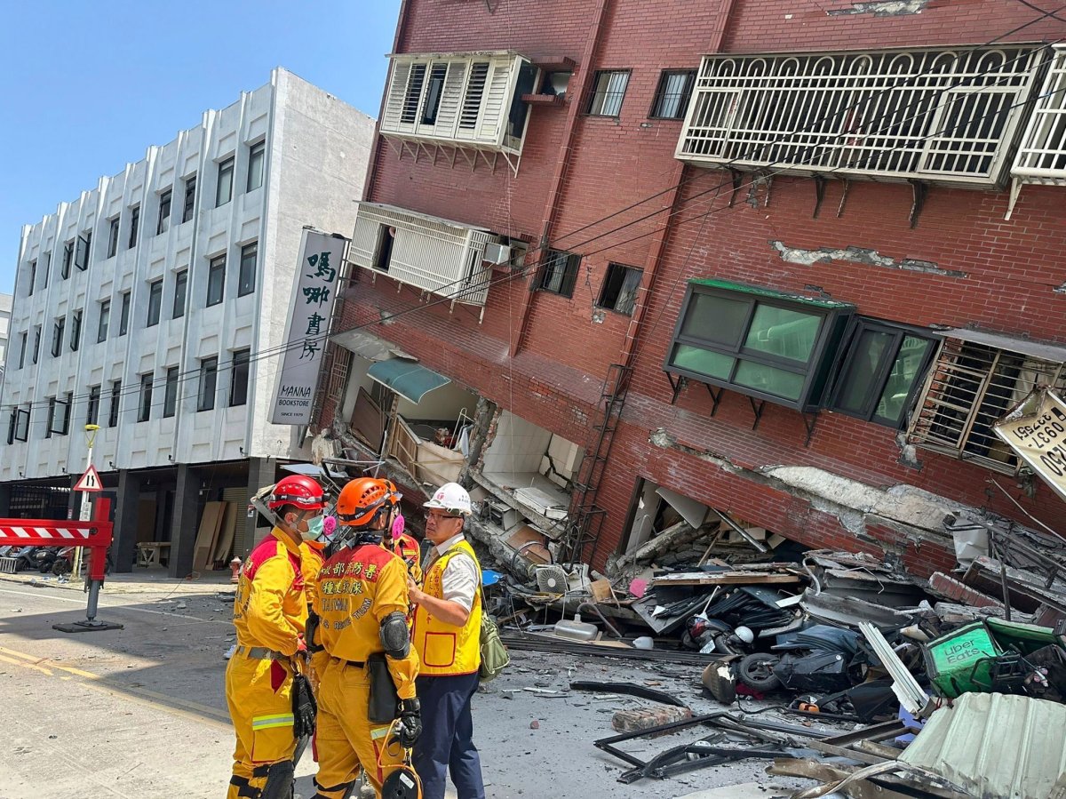 Members of a search and rescue team prepare to enter a leaning building after strong earthquake