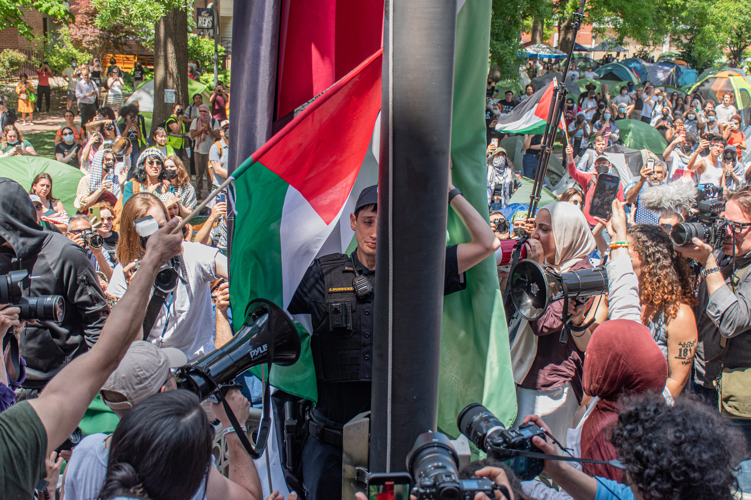 A George Washington University police officer lowers a large Palestinian flag raised by student demonstrators in violation of university policy in Washington, D.C., on May 2.
