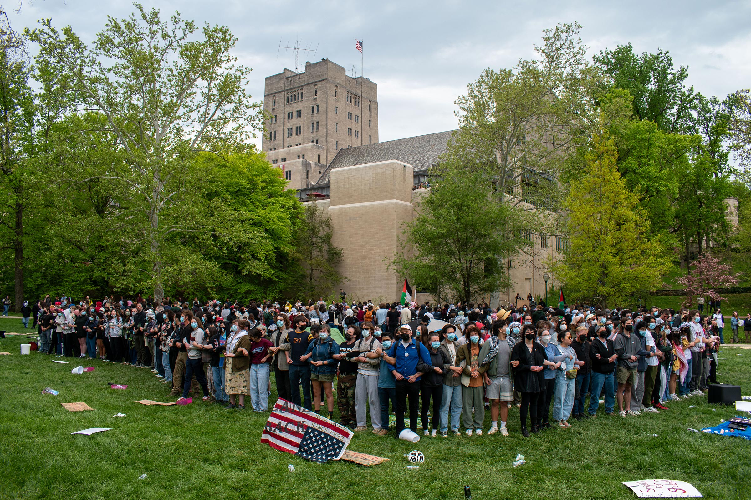 More than 100 pro-Palestinian protesters link arms to surround an encampment on April 26, outside the Indiana Memorial Union in Bloomington. Inside the encampment, there was food, medical supplies, tents, and a pile of backpacks.